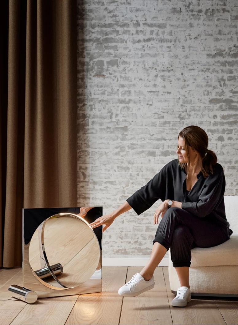 Designer Anne Boysen rotates the diffuser of Moonsetter, a floor light she designed for Louis Poulsen